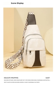 Detail of off-white canvas chest bag with brown leather trim and patterned woven strap