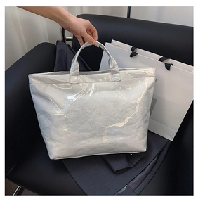 Macro shot of silver Tyvek tote bag with wrinkled texture on a black leather seat