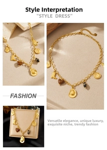 Detail of gold necklace featuring western cowboy boot, hat, and heart charms on stone