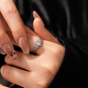 Close-up of a silver wheat crown ring with zircon stones worn on model's finger