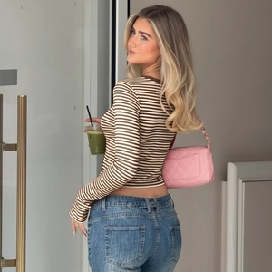 Detailaufnahme des braun-weiß gestreiften langärmeligen Crop-Tops mit blauer Jeanshose