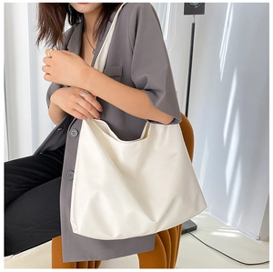 Detailed view of a white large capacity faux leather tote bag worn on shoulder