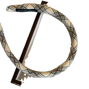 Classic beige plaid pattern headband with handmade label on professional display stand