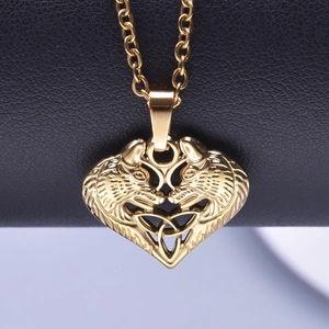 Detail of 18k gold heart pendant with Celtic wolf head design on a gold cable chain