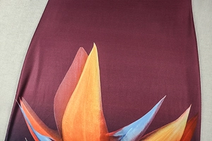 Detail of burgundy dress fabric featuring large tropical bird of paradise floral print