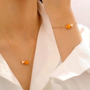 Détail du collier à pendentif cœur doré et breloque tennis porté par un mannequin