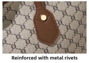 Detail of reinforced gold metal rivets and brown leather strap on retro patterned tote bag