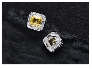 Macro shot of 925 silver square yellow cushion cut diamond earrings on black stone