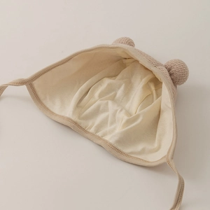 Cute beige infant knit hat with double pom-poms and soft lining for baby comfort