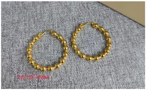Vue macro de boucles d'oreilles créoles perlées de 30mm en or poli au style minimaliste