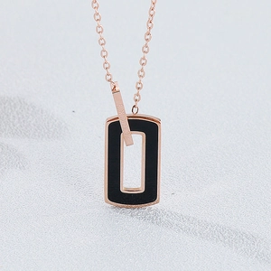Macro shot of rose gold lucky bar and black rectangle pendant on a stylish chain
