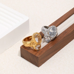 Detail of gold and silver hammered cocktail rings with large oval cubic zirconia stones