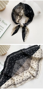 Macro detail of pleated scarf with black and white paisley pattern and textured fabric