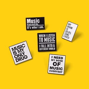 Set of five music-themed black and white enamel pins on a vibrant yellow background