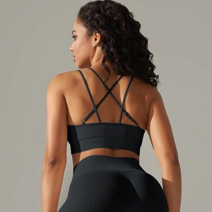 Detail of cross-back straps and ribbed texture on black seamless sports bra and leggings