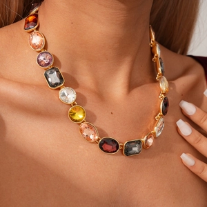 Detailed view of vintage multi-shaped crystal pendants on a gold long chain necklace