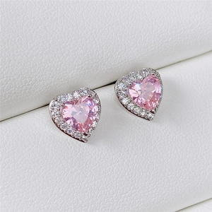 Macro view of pink heart-shaped cubic zirconia stud earrings with silver-tone halo setting
