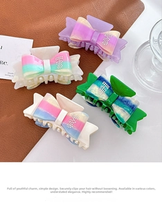 Detailed view of four large gradient acetate bow hair claws with sparkling diamond accents