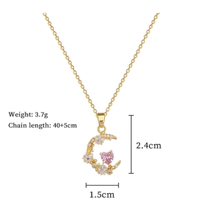 Detail view of gold crescent moon necklace with pink heart crystal and size dimensions