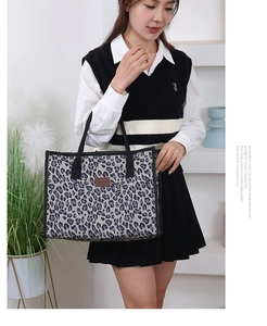 Fashionable leopard print canvas tote bag with black strap and leather logo detail