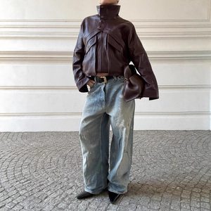 Veste courte style motard en similicuir marron foncé avec jean délavé à jambes larges