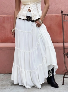 Detail of white tiered maxi skirt featuring lightweight chiffon layers and bohemian styling