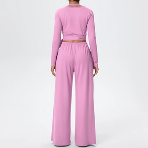 Détail de l'ensemble de yoga rose montrant le haut à lacets et le pantalon à taille haute