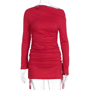 Detail of ruched red knit dress showing side drawstring and asymmetric pleated neckline