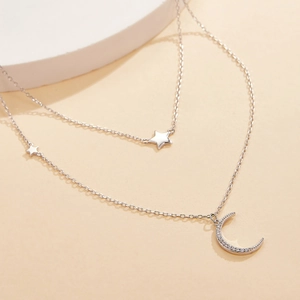 Close-up of double-layer S925 silver necklace with pavé moon and star pendants