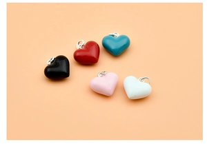 Close-up of colorful heart-shaped 925 silver resin pendants in five vibrant colors