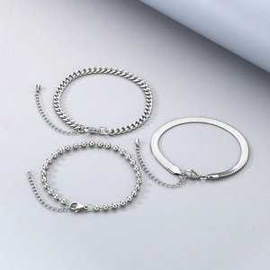 Detailed close-up of silver Cuban, snake, and bead chain bracelets with lobster clasps