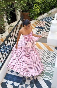 Close-up of pink polka dot strapless dress with ruffled tiered hem and flared silhouette