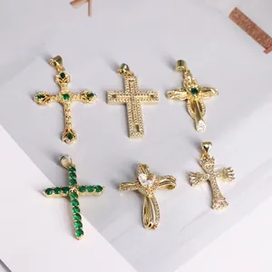 18K gold cross pendants with emerald and opal stones on a minimalist magazine background