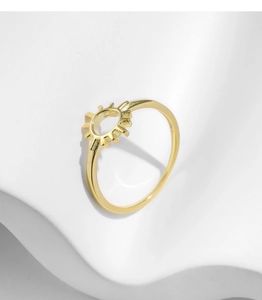 Detail of s925 silver sun-shaped gold ring displayed on a white minimalist wave prop