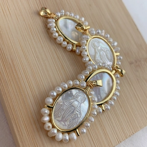 Détail des pendentifs en perles d'eau douce et nacre sculptée Vierge Marie