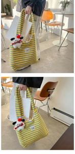 Detail of yellow and blue striped knit tote bag with plush texture and cartoon charm