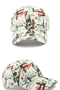 Detalle de gorra de béisbol blanca con estampado de Torre Eiffel y figuras de moda