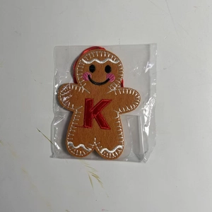 Macro view of gingerbread man felt ornament featuring red embroidered letter K detail