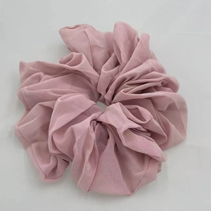 Detailed view of a soft pink chiffon oversized scrunchie with elegant ruffled texture