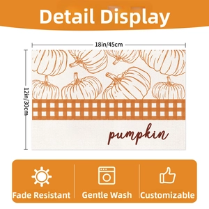 Detail of pumpkin print placemat with orange plaid accent and 45x30cm size specs