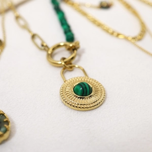 Vue macro d'un collier vintage doré avec pendentif en malachite et détails ciselés