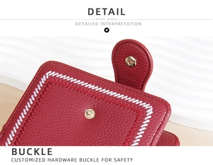 Macro view of a red leather wallet featuring a durable hardware snap buckle and white stitching