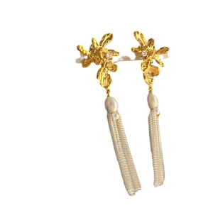 Boucles d'oreilles fleur dorée avec pompons blancs et perles pour un look vintage