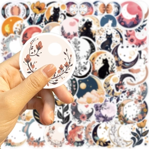 Close-up of bohemian moon, black cat, and floral waterproof stickers for DIY decoration