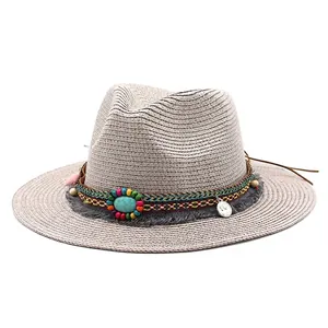 Detail van de bohemien strohoed met kleurrijke kralen, turquoise steen en grijze kwastjes