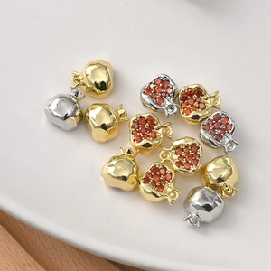Macro shot of 14K gold plated pomegranate charms with red cubic zirconia for jewelry