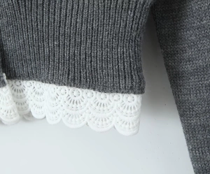 Détail du tissu en maille gris foncé avec bordure délicate en dentelle blanche