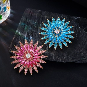 Detailed close-up of crystal snowflake brooch with vibrant blue and pink gemstones