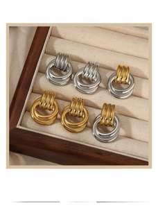 Close-up of retro mixed metal triple hoop earrings on a beige velvet jewelry tray