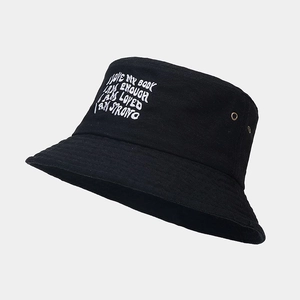 Détail de broderie blanche et d'œillet métallique sur bob en coton noir